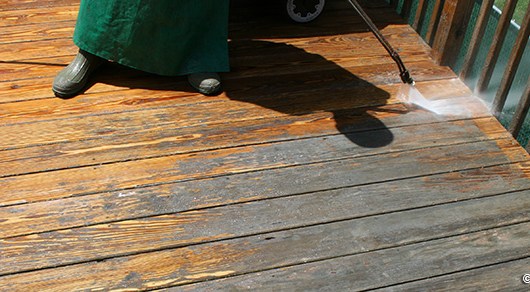 Photo of power washing and stripping a deck.