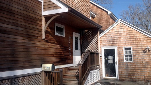 Close up of cedar house showing mold and worn finish.