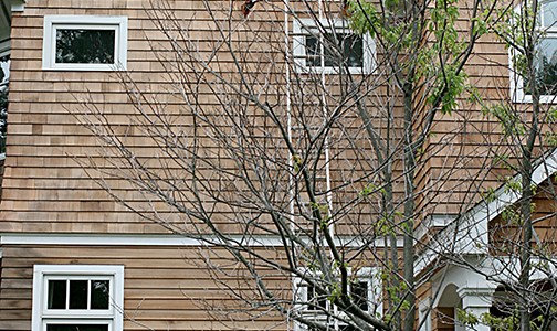 Closeup of front side of cedar house prepped for oiling.